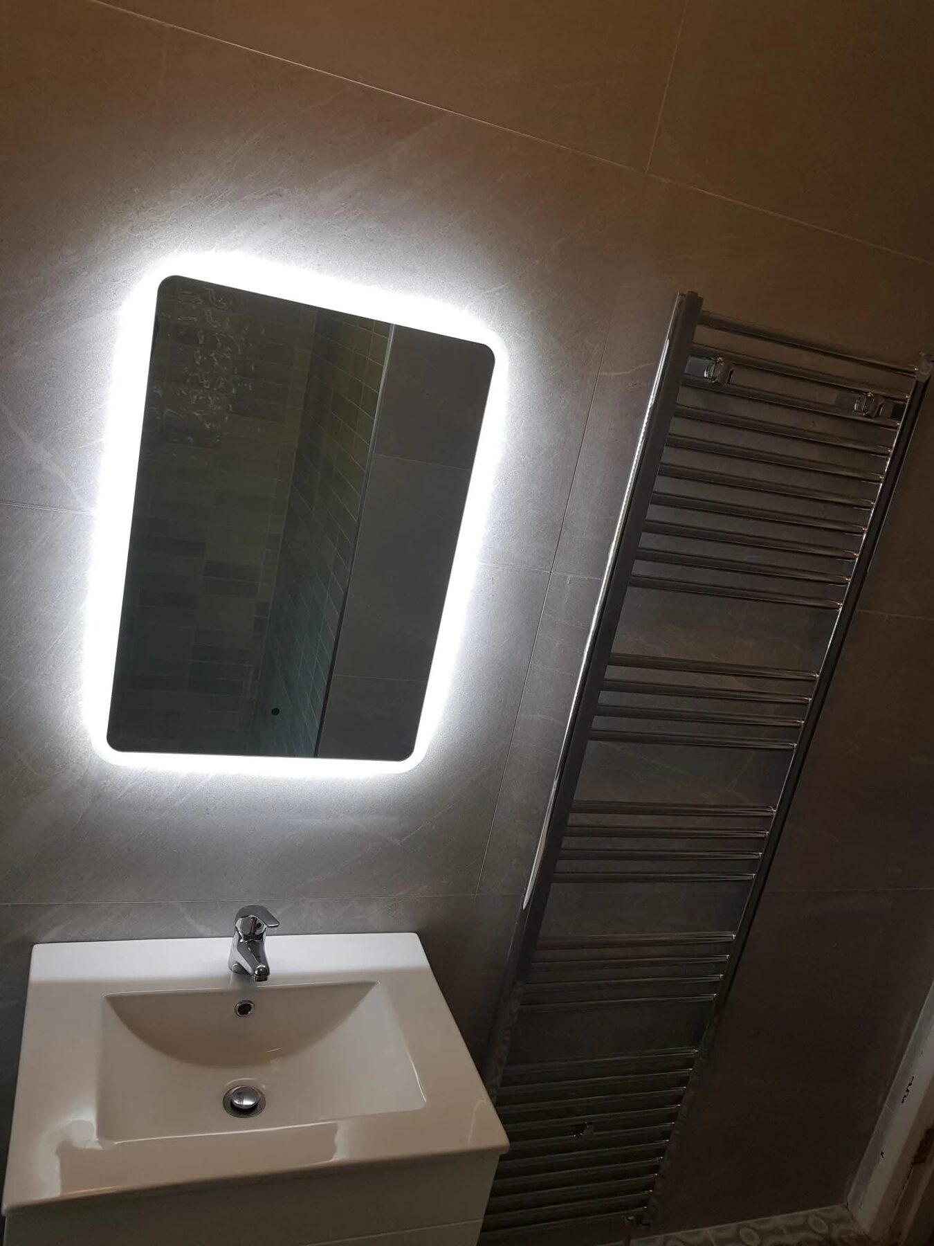 Bathroom vanity with backlit LED mirror and heated towel rail, fitted by AJ Bathrooms Dublin